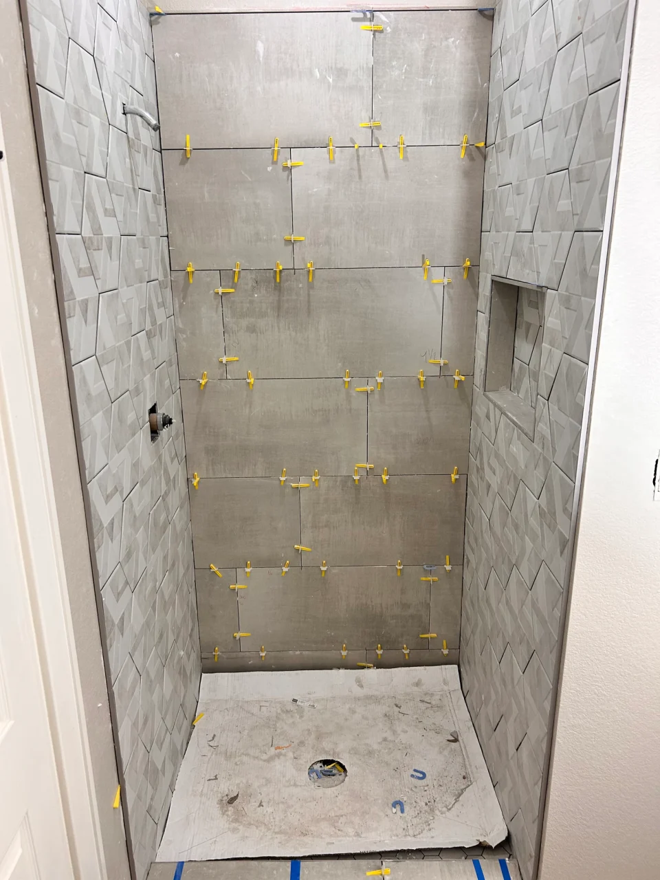In progress: shower tile installation with leveling clips