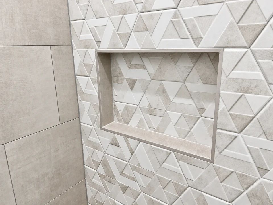 Finished shower: geometric tile and recessed niche detail