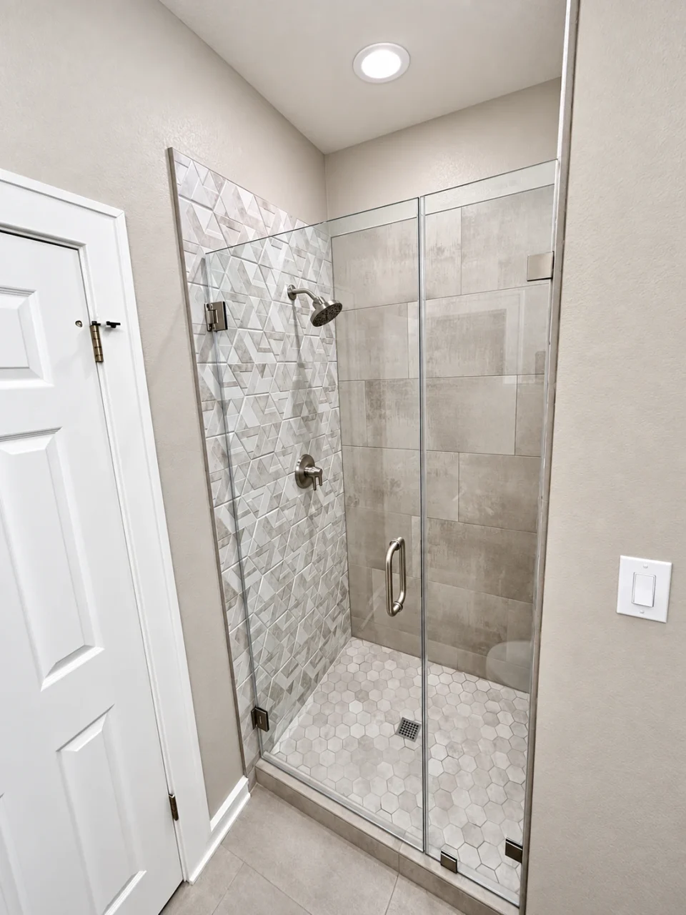 Finished shower: glass enclosure and geometric accent tile
