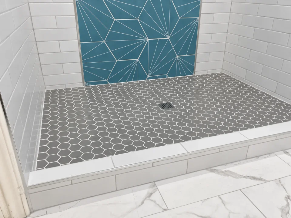 Mosaic shower floor beneath the blue accent wall