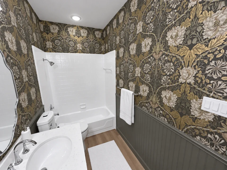White bathtub and surround beside botanical wallpaper, dark beadboard and a neatly hung white bath towel.