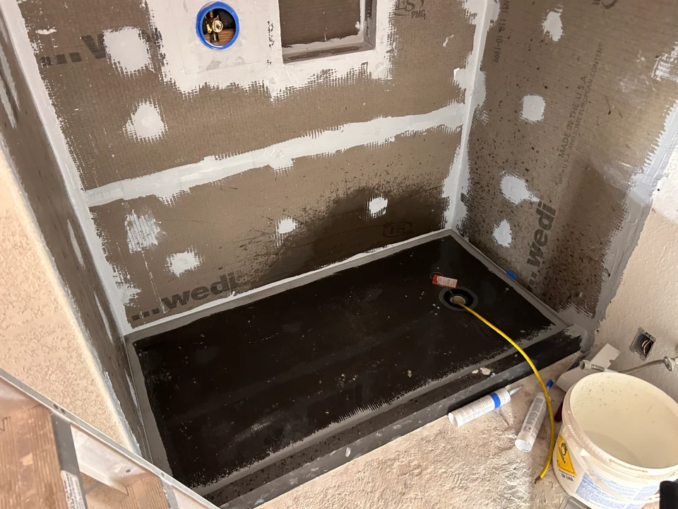 Shower base, sealed wall panels and recessed niche before tile installation