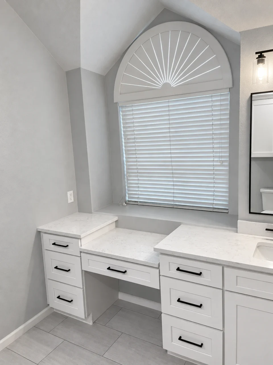 White cabinetry beneath the bathroom window