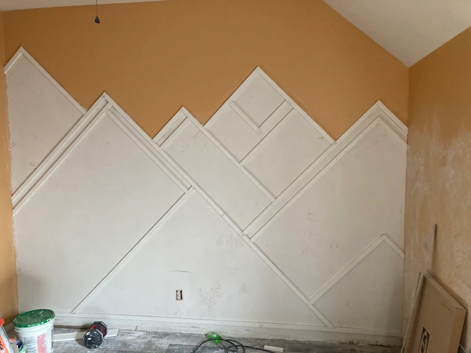 In progress: mountain-shaped bedroom wall trim with unfinished panels before painting