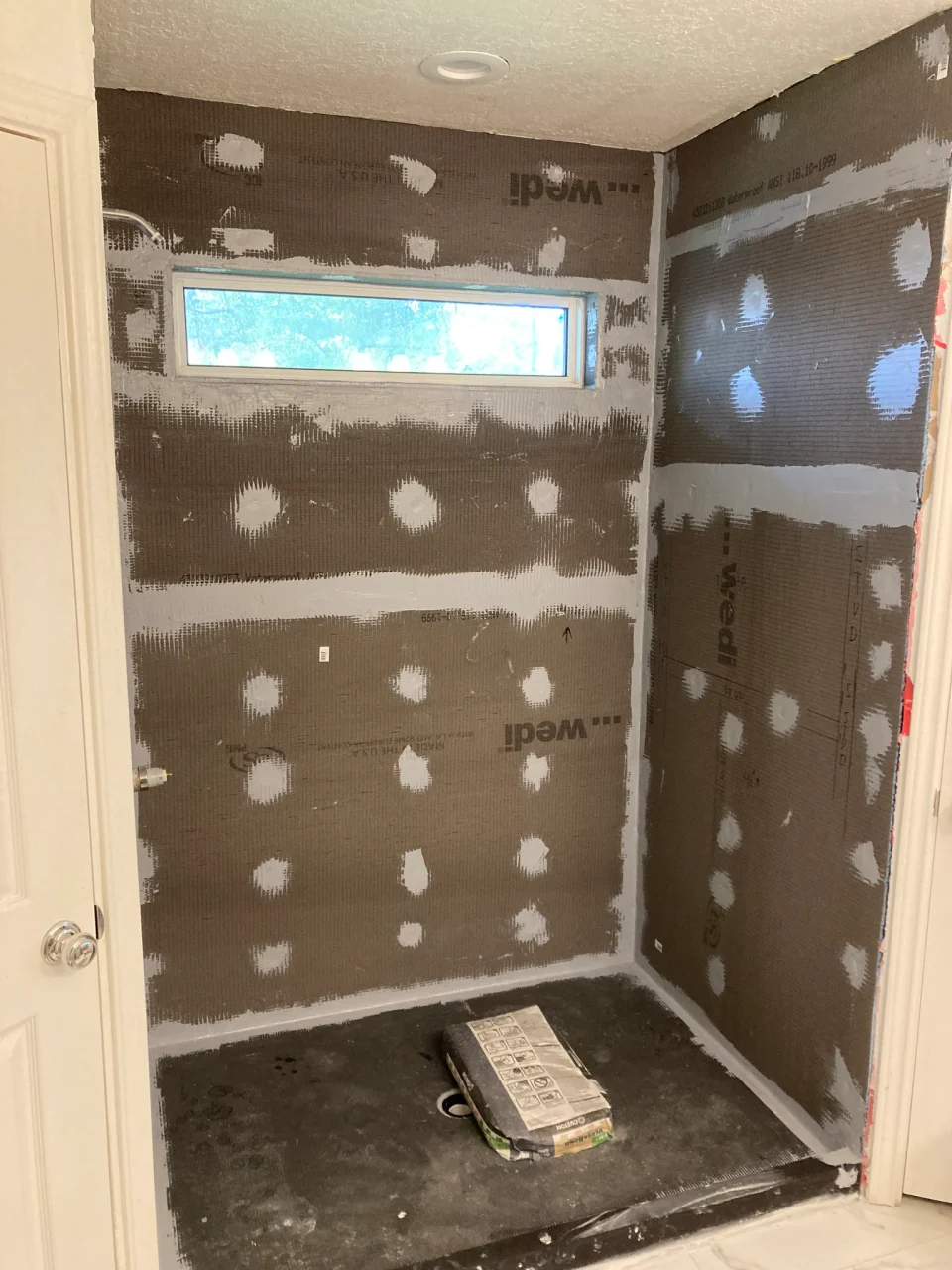 Shower wall boards, sealed joints and the prepared shower base before tiling