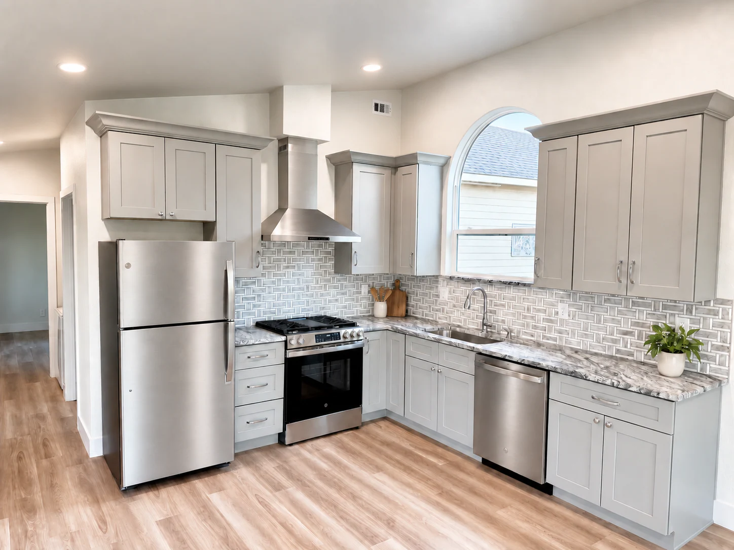 ADU kitchen with pale cabinets and a stainless steel range