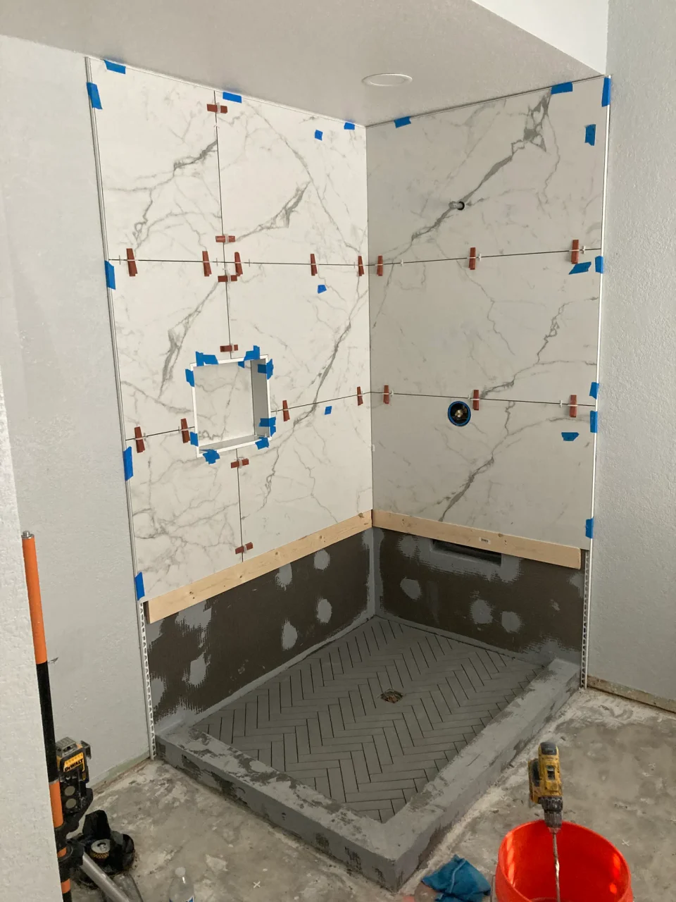 Large-format shower wall tile during installation