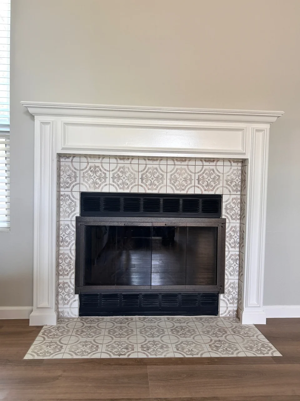 Fireplace with patterned tile surround and white mantel