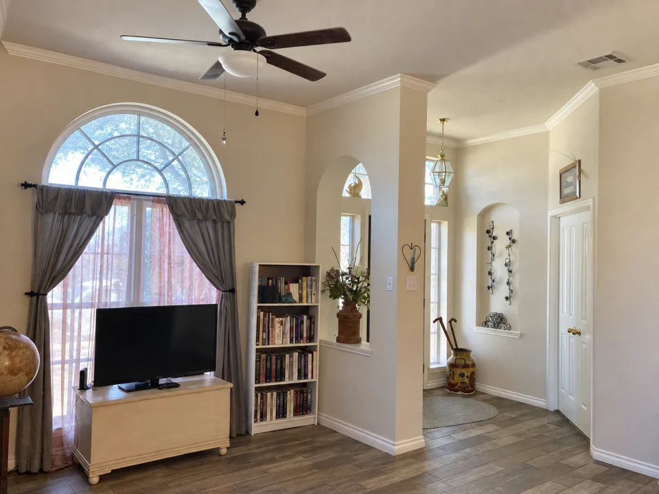 Before renovation: living room and entry with an arched window