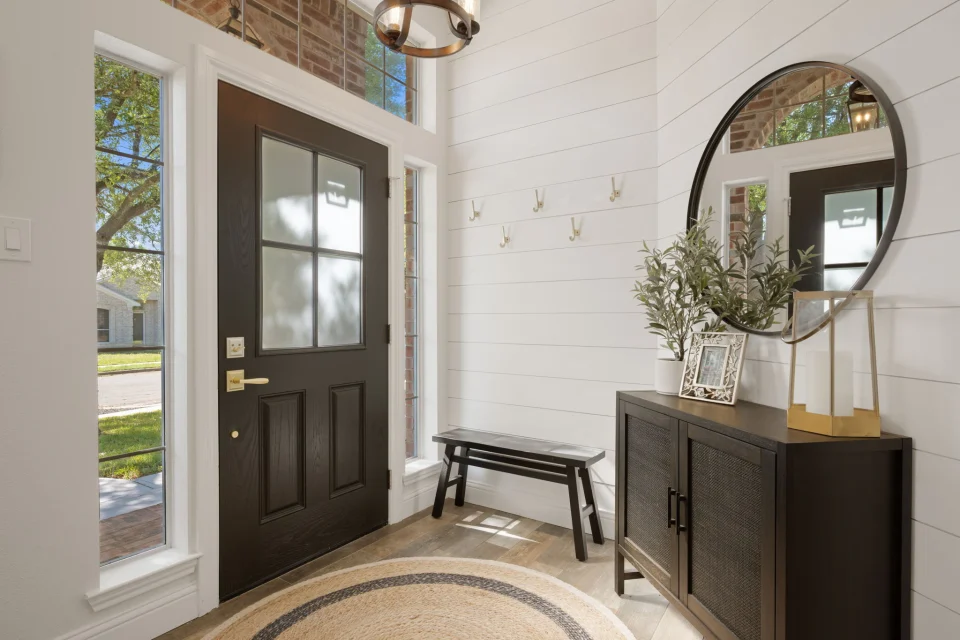 Refreshed front entry with custom wall detailing and glazed door.