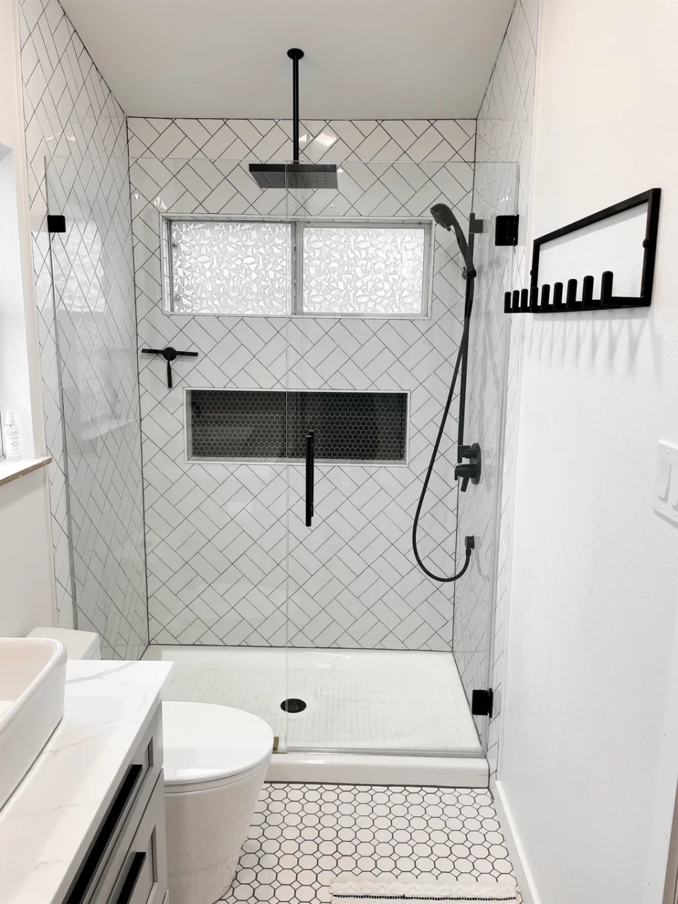 White basket-weave shower with dark niche and black fixtures