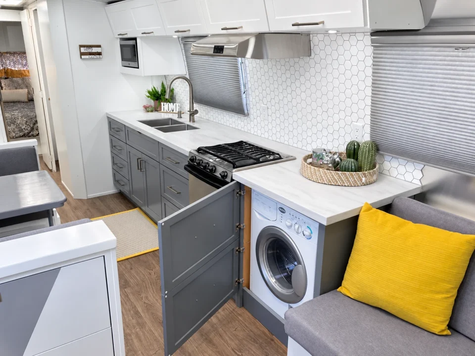 Airstream kitchen with cooktop, sink, and compact washing machine