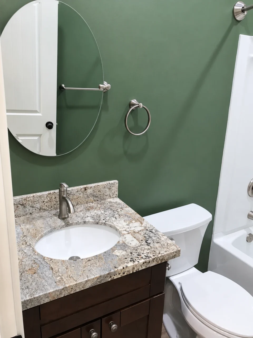 Bathroom vanity with round mirror beside the toilet