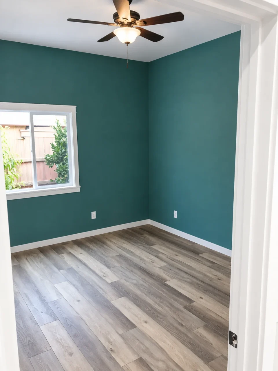 Bedroom with dark green walls and a ceiling fan
