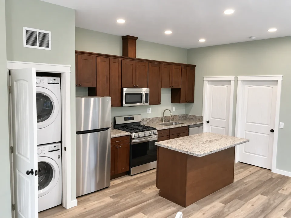 Attached ADU kitchen with island and stacked laundry