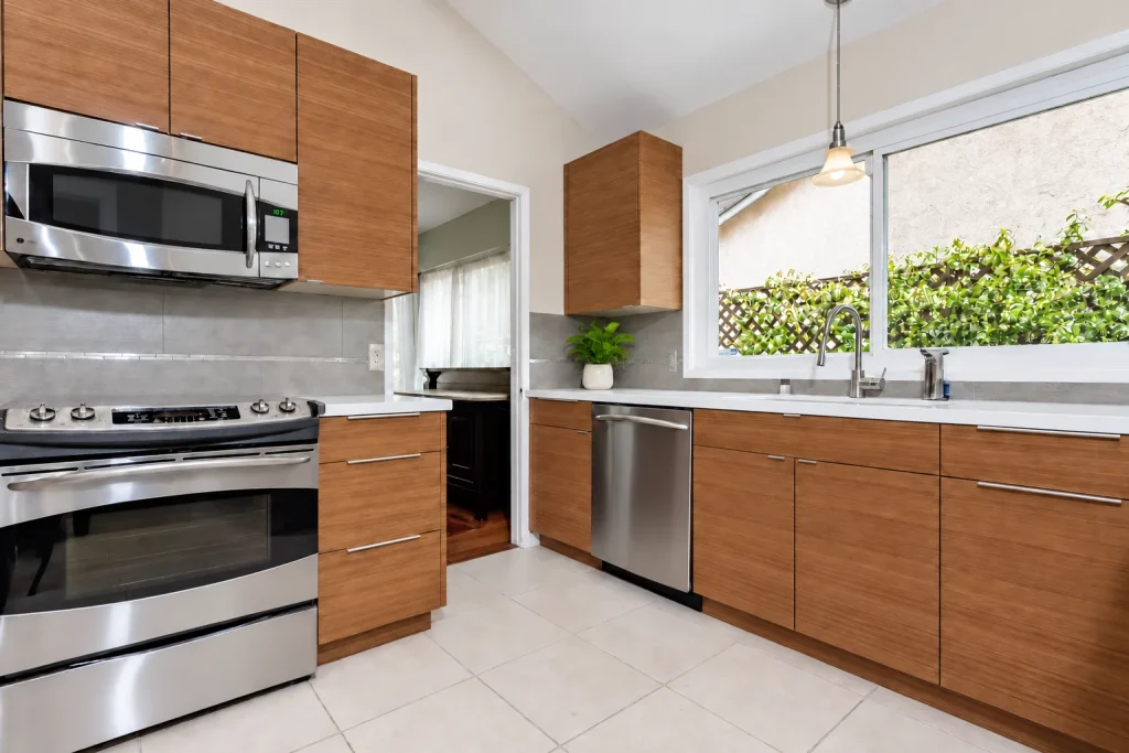 Wood kitchen cabinetry with stainless range and a bright window