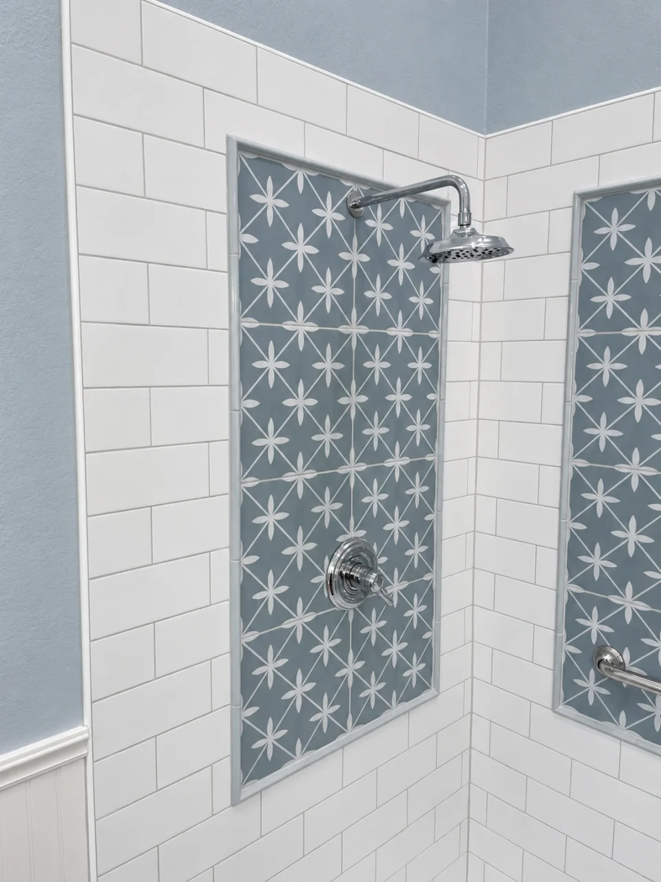 Blue-gray star-patterned shower panels framed by white subway tile