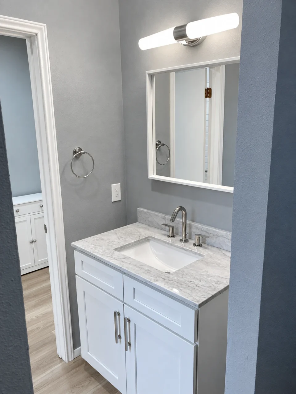 White bathroom vanity with mirror and wall light