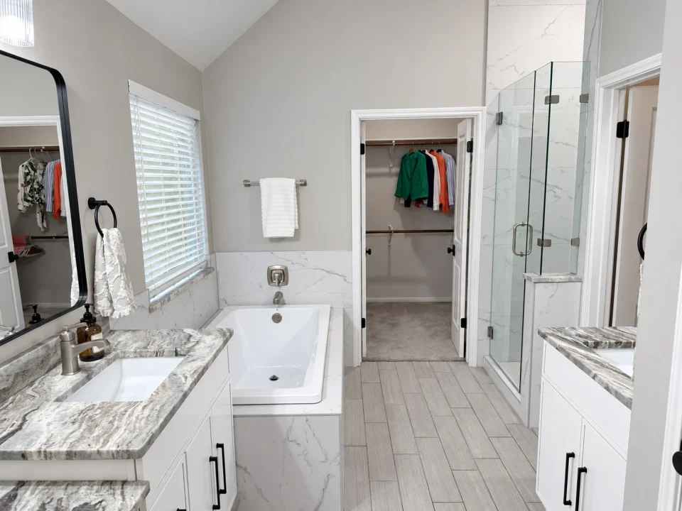 Primary bedroom ensuite with a shower, bathtub, and double vanity.