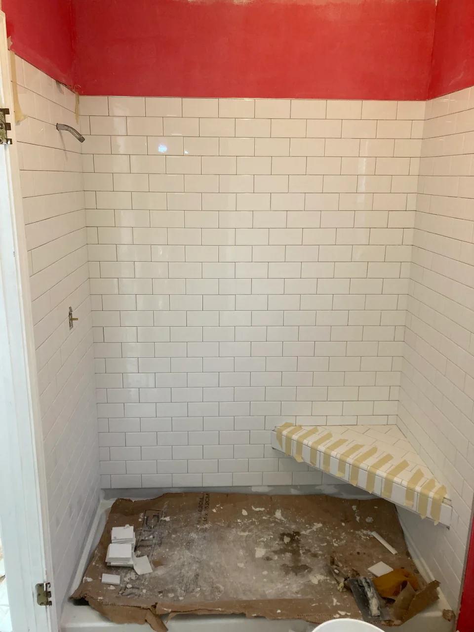 In progress: closer view of subway tile walls and taped corner bench before completion
