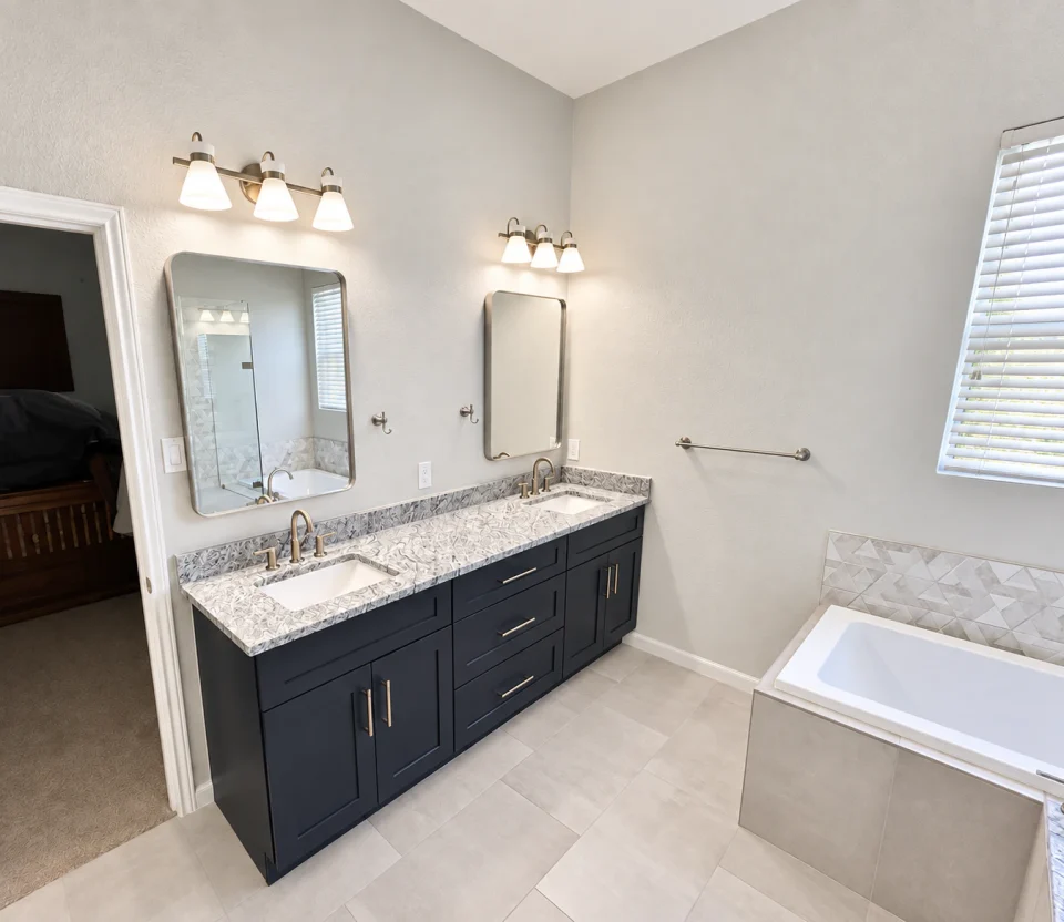 Dark bathroom vanity with two mirrors beside a bathtub