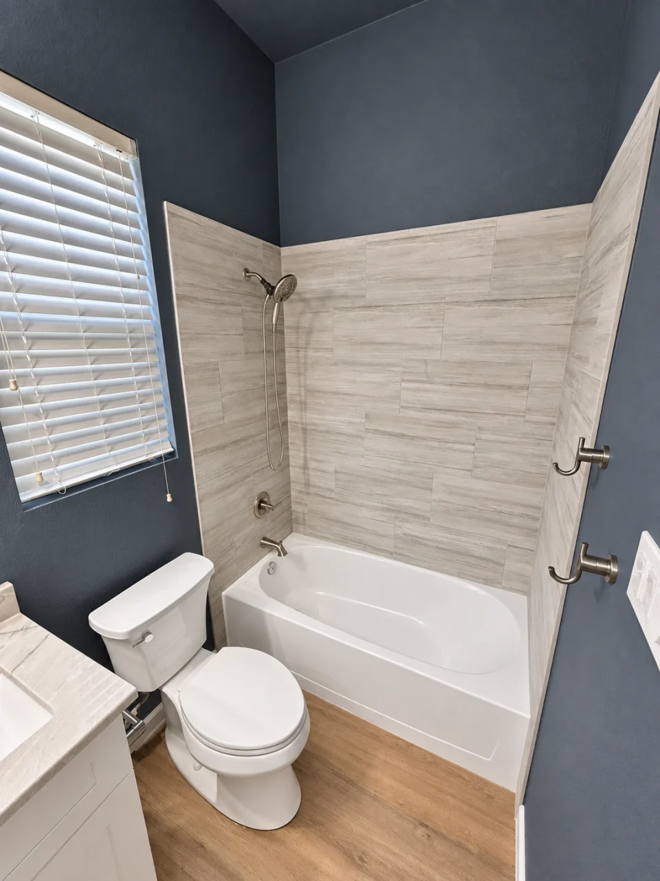 Guest bathroom with dark walls and a white tub surround